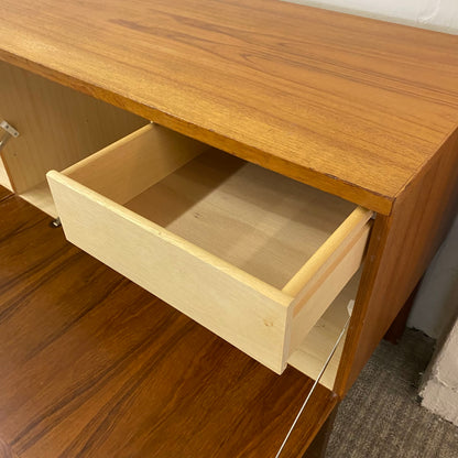 Wooden desk with an open drawer on a wooden floor.