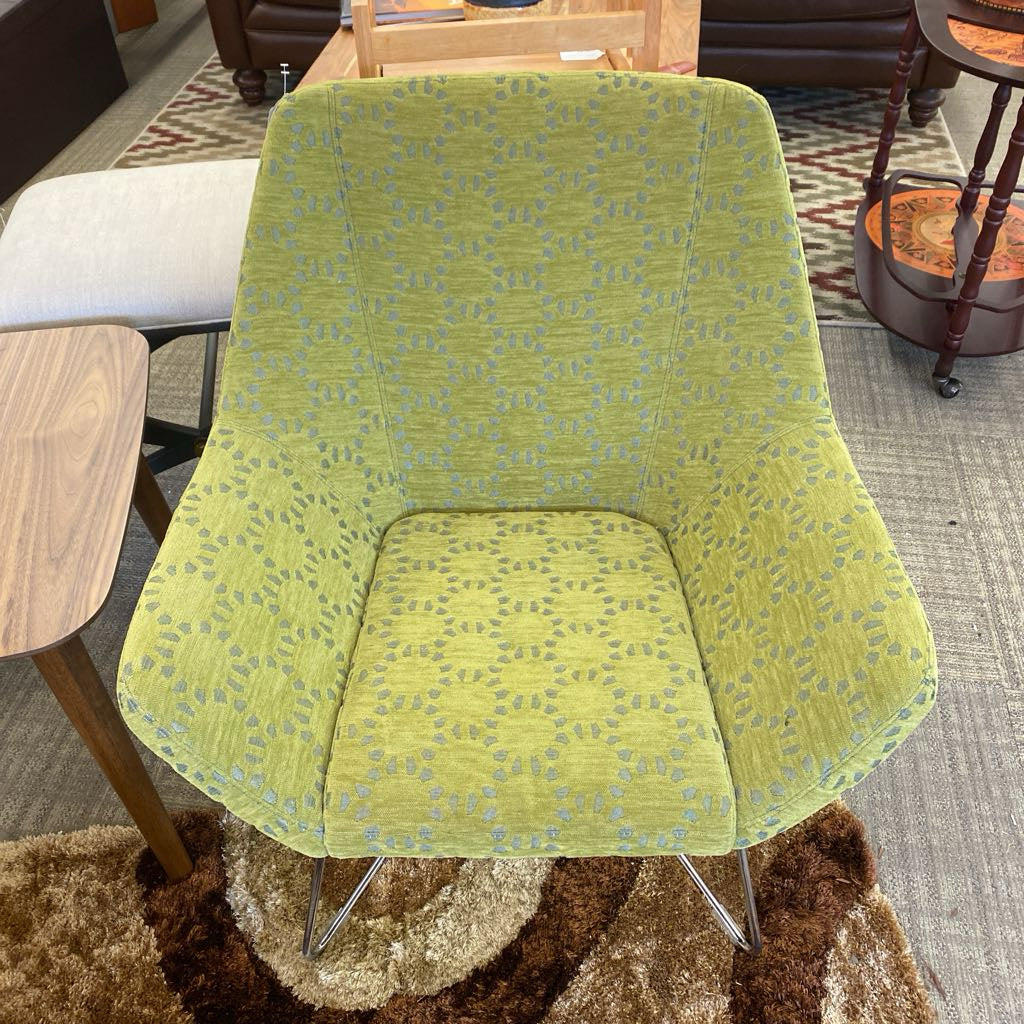 Green patterned chair in a room with furniture and carpet