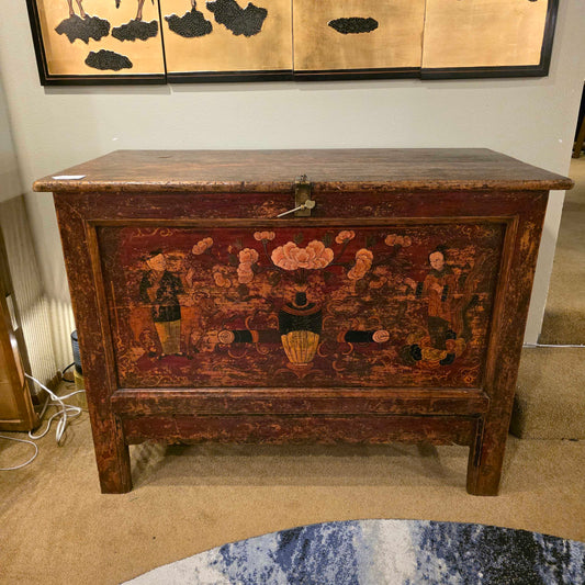 Vintage wooden chest with decorative paintwork in a room setting.