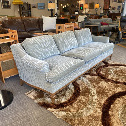 Patterned sofa in a showroom with furniture and decor around