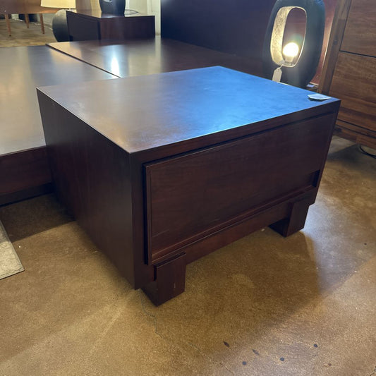 Dark wooden desk in a room with a lamp and chair