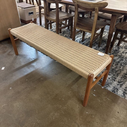 Woven bench with wooden frame on a concrete floor in an indoor setting