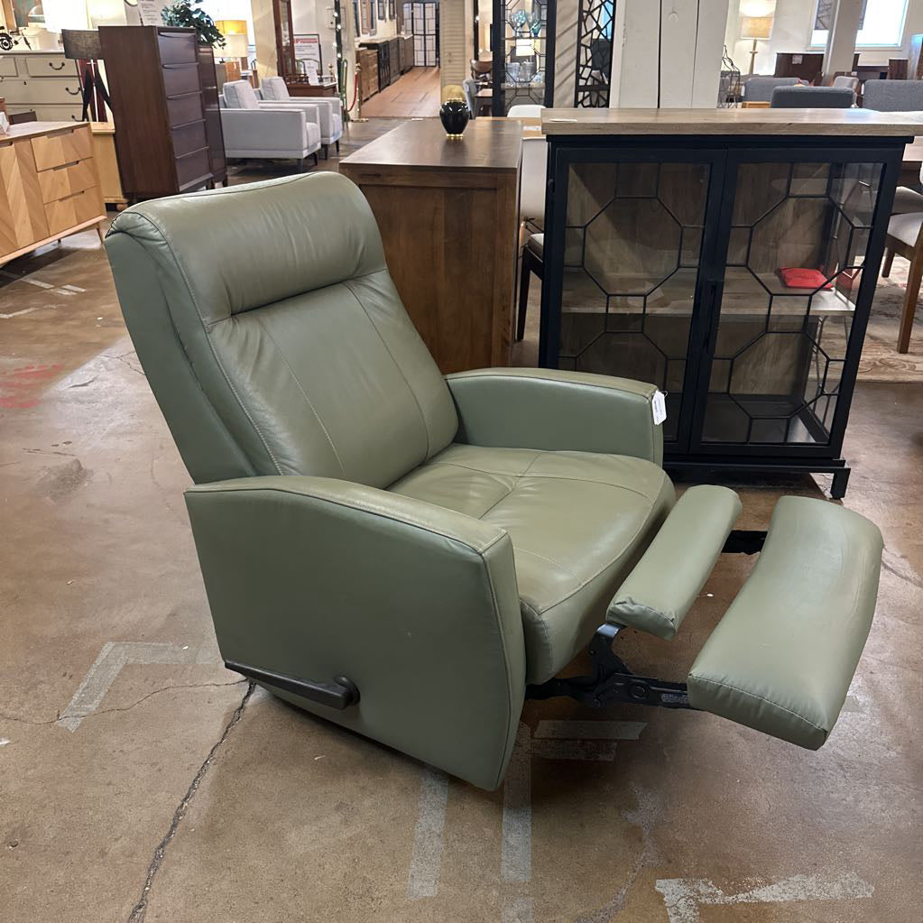 Green leather recliner chair in a furniture store setting
