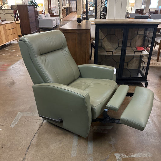 Green leather recliner chair in a furniture store setting