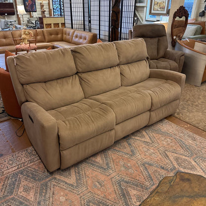 Beige sofa in a room with a patterned rug and furniture.