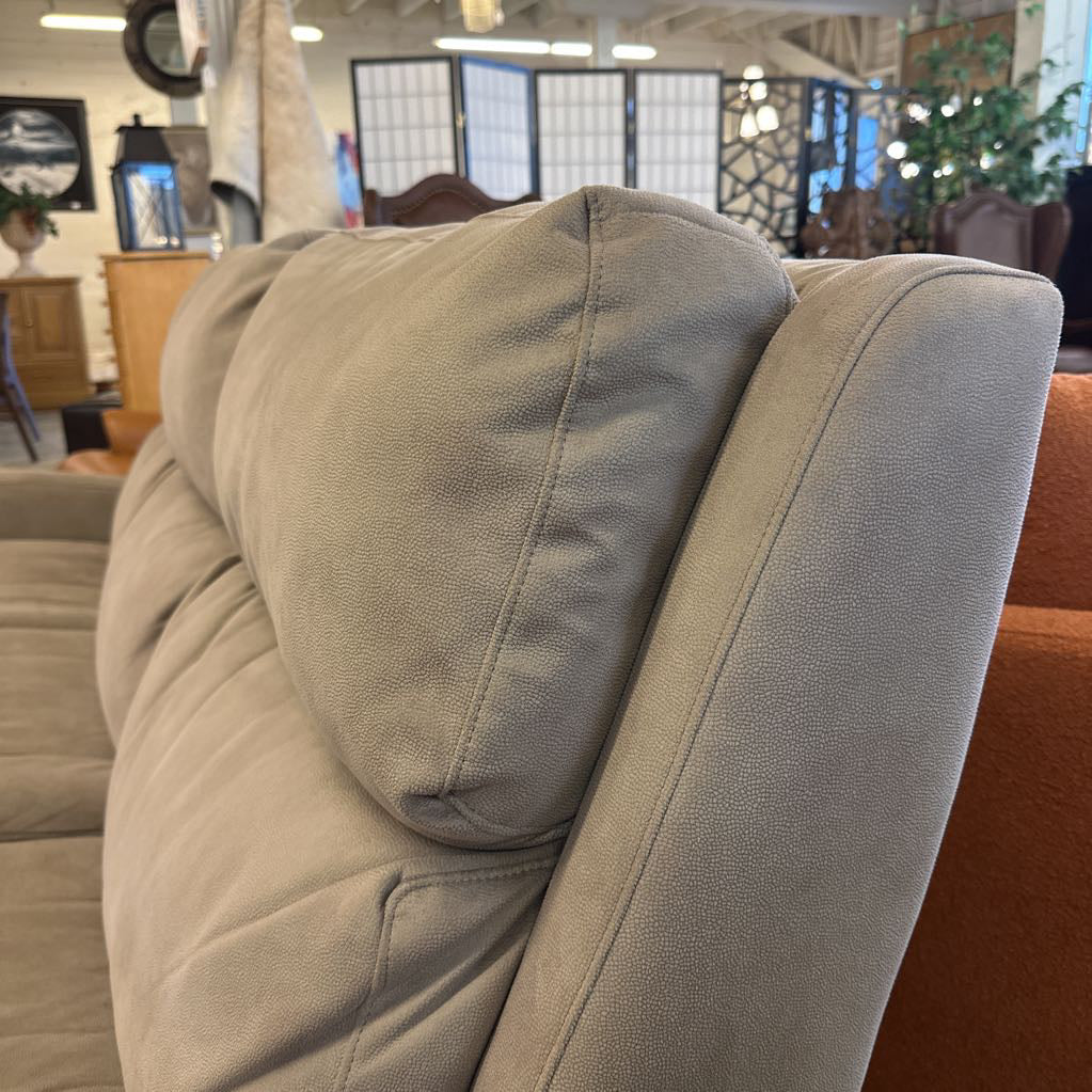 Close-up of a beige upholstered chair with a blurred background