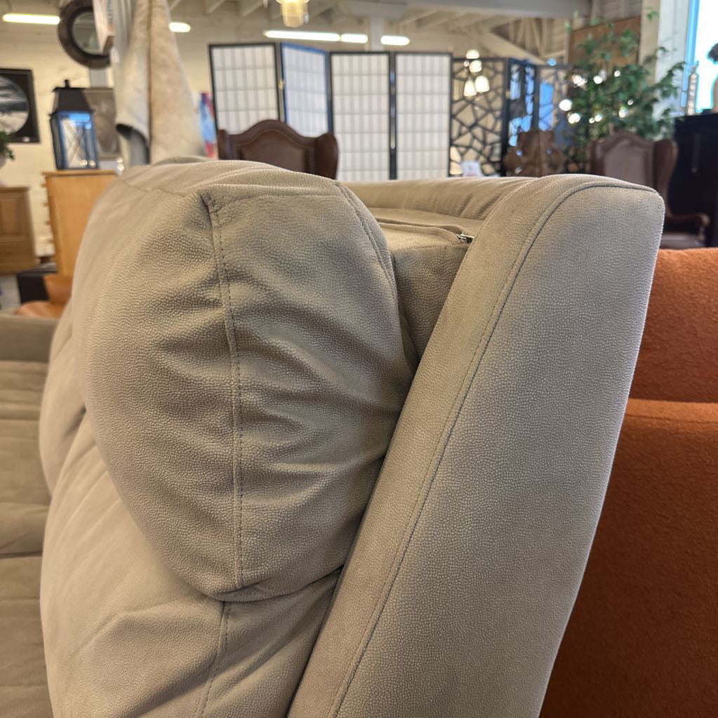 Close-up of a beige sofa with a blurred background of a furniture store.