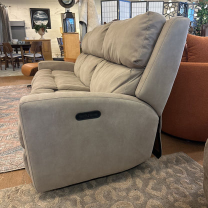 Gray recliner sofa in a room with furniture and decor.