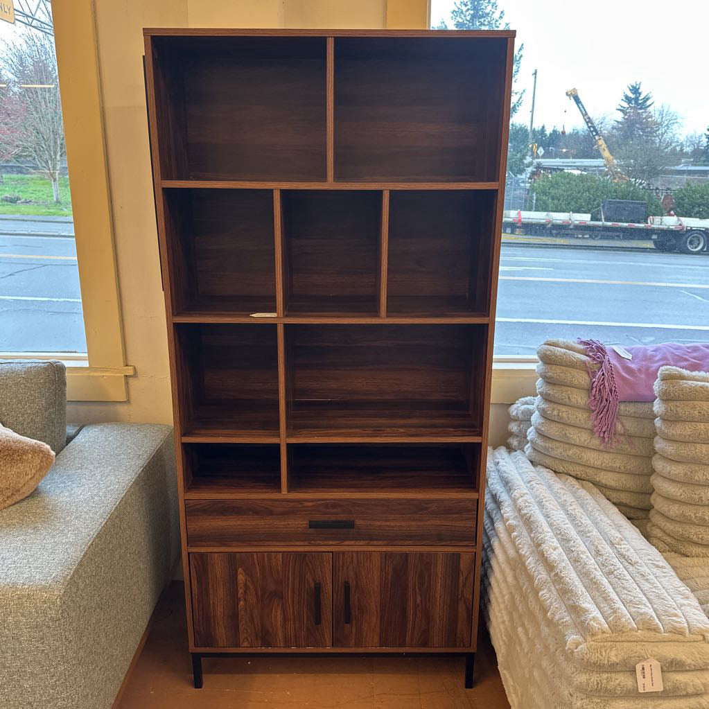 Wooden bookshelf in a room with furniture and a window view.
