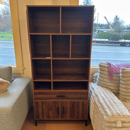 Wooden bookshelf in a room with furniture and a window view.