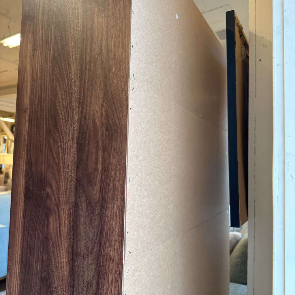 Close-up of wooden panel and cardboard roll with blurred indoor background