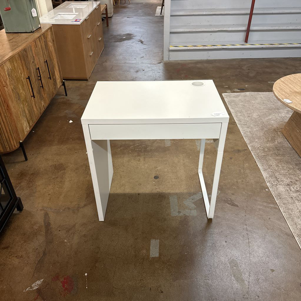 White table in a warehouse setting with wooden cabinets and flooring.
