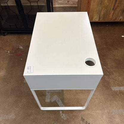 White square table with a circular hole on a brown floor