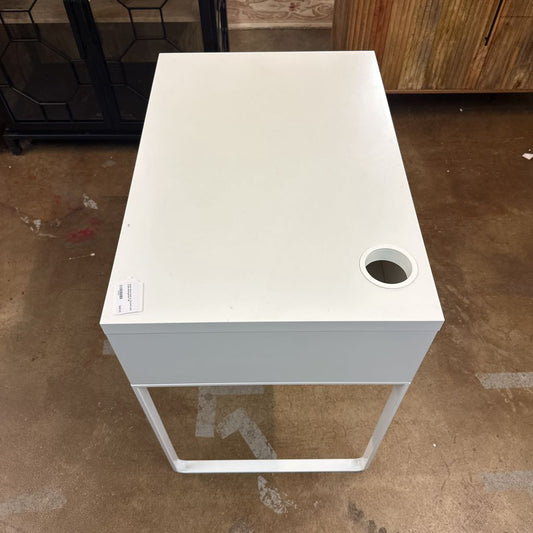 White square table with a circular hole on a brown floor