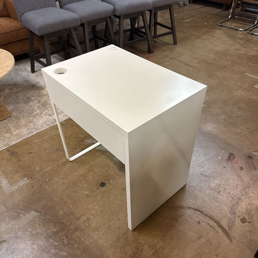 White desk in a room with chairs and a concrete floor