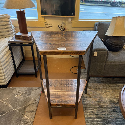 Wooden table with two shelves in a room with furniture and decor.