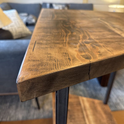 Close-up of a wooden table corner with a blurred background
