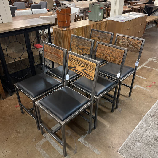 Wooden chairs with black seats in a store setting