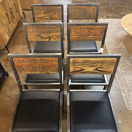 Set of wooden chairs with black seats in a showroom setting