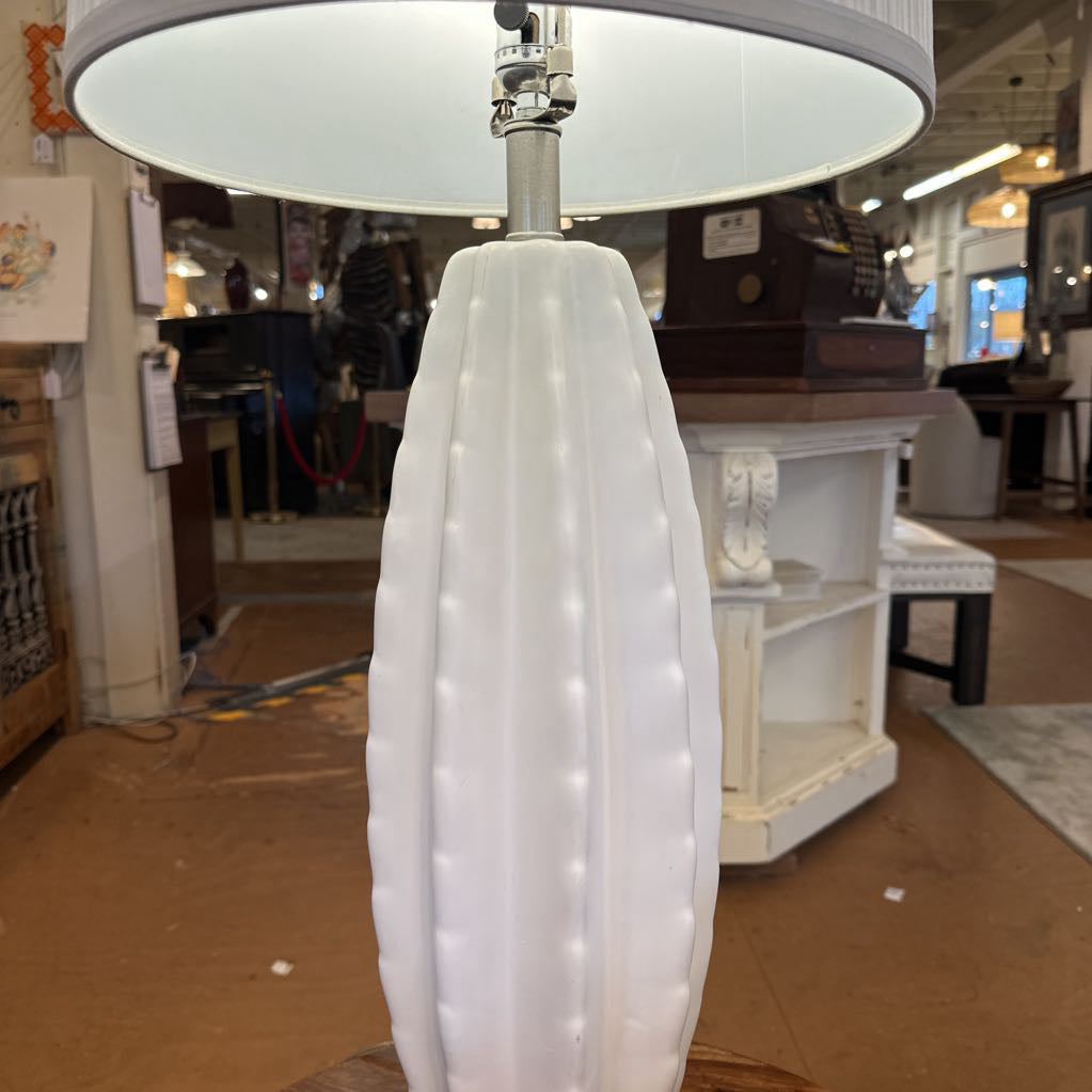 White lamp with a textured base in a store setting