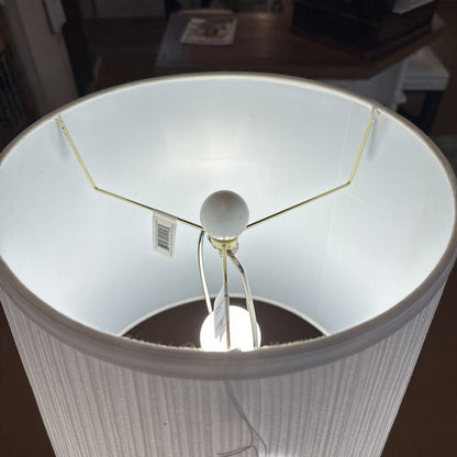 Close-up of a lamp with a white shade and base.