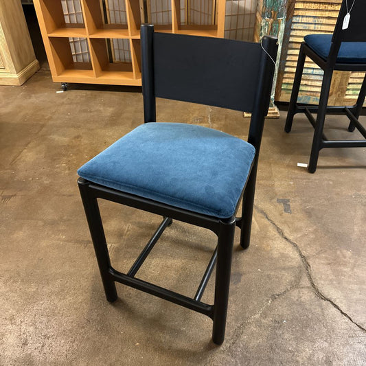 Chair with blue cushion on a concrete floor in an indoor setting
