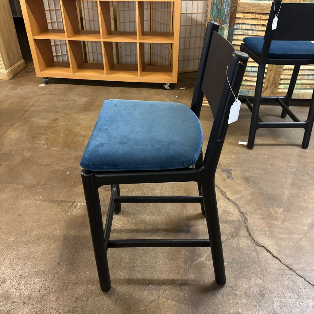 Chair with blue cushion on a concrete floor in an indoor setting