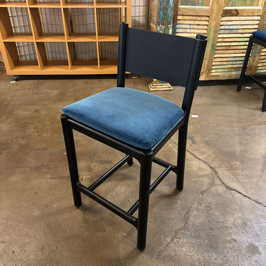 Chair with blue cushion on a concrete floor in an indoor setting