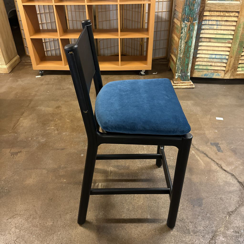 Chair with a blue cushion on a concrete floor in an indoor setting