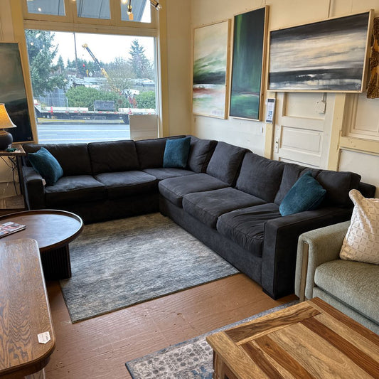 Living room with a sectional sofa, coffee table, and wall art.