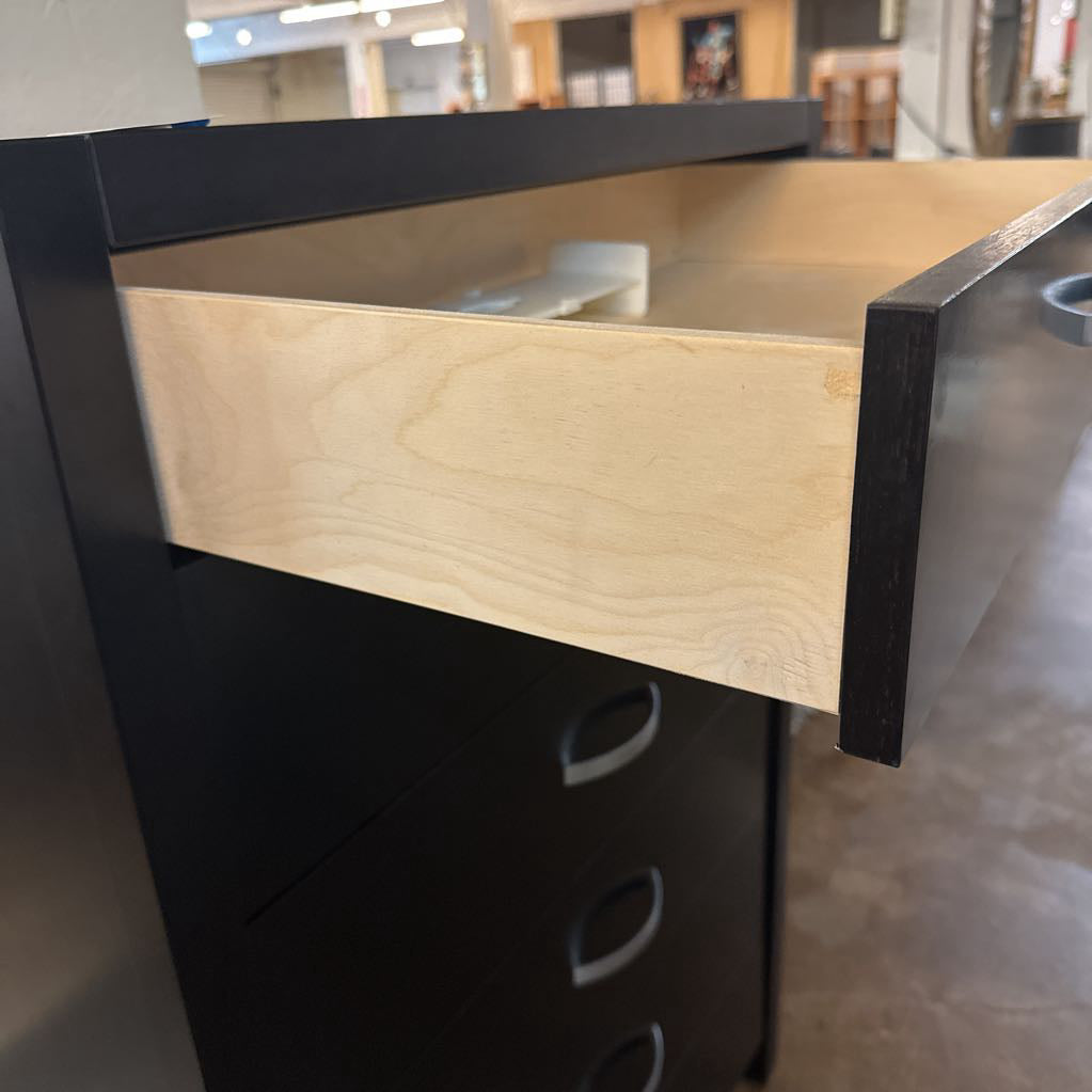 Wooden drawer on a black cabinet with blurred background