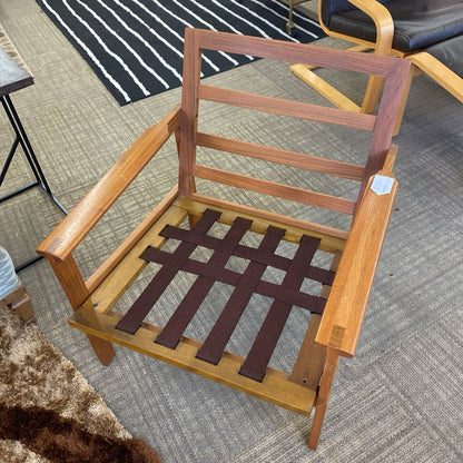 Wooden chair with a lattice seat on a carpeted floor