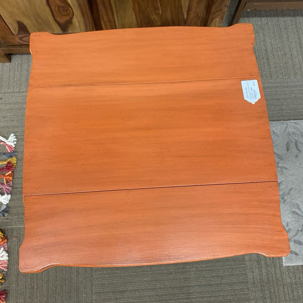 Wooden stool on a carpeted floor with a small tag attached