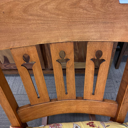 Wooden chair with decorative backrest on a blue carpeted floor
