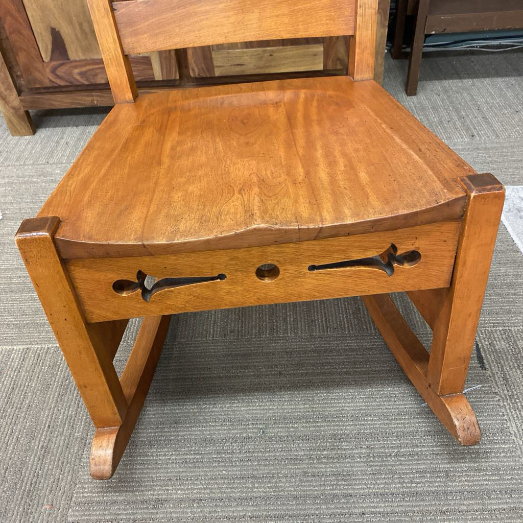 Wooden chair with a seat and backrest on a gray carpeted floor.