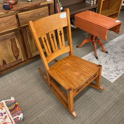Wooden chair and table on a gray floor with furniture in the background
