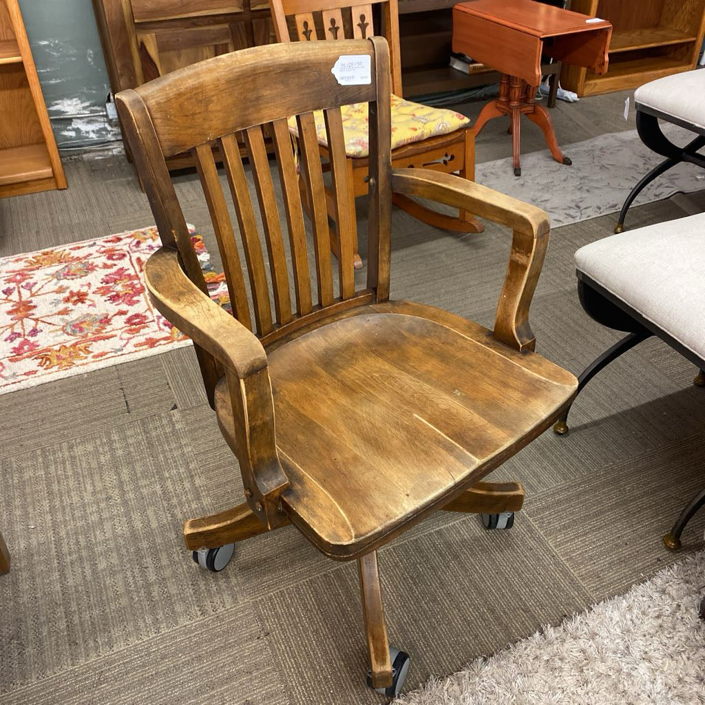 Wooden office chair with wheels in a furniture store setting