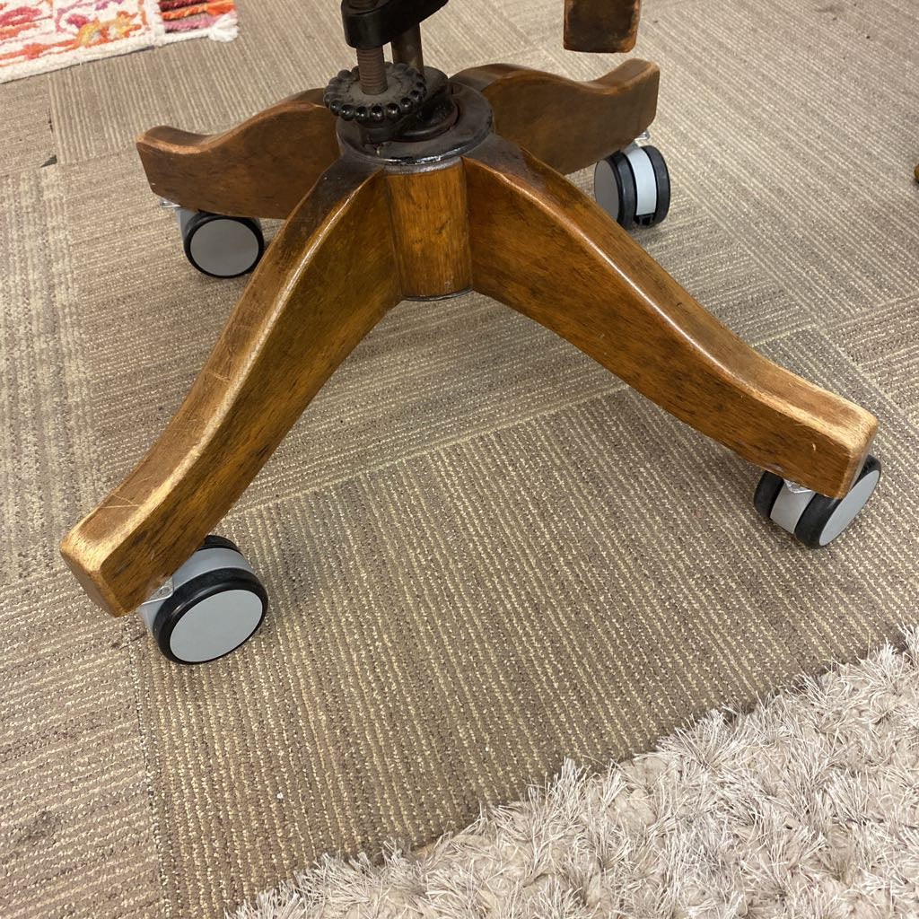 Wooden office chair base with wheels on a carpeted floor