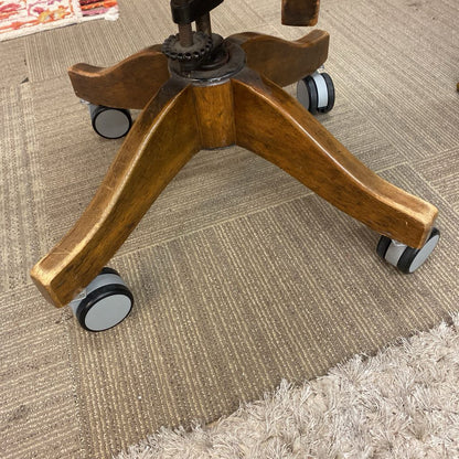 Wooden office chair base with wheels on a carpeted floor