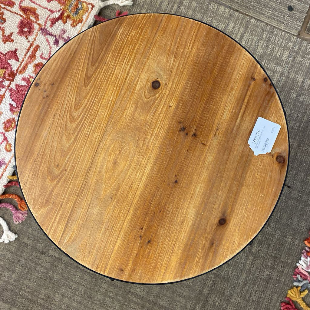 Round wooden surface with a label on a textured rug