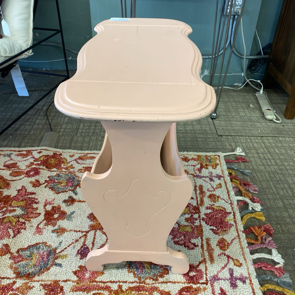 Beige decorative pedestal table on a patterned rug with a room background