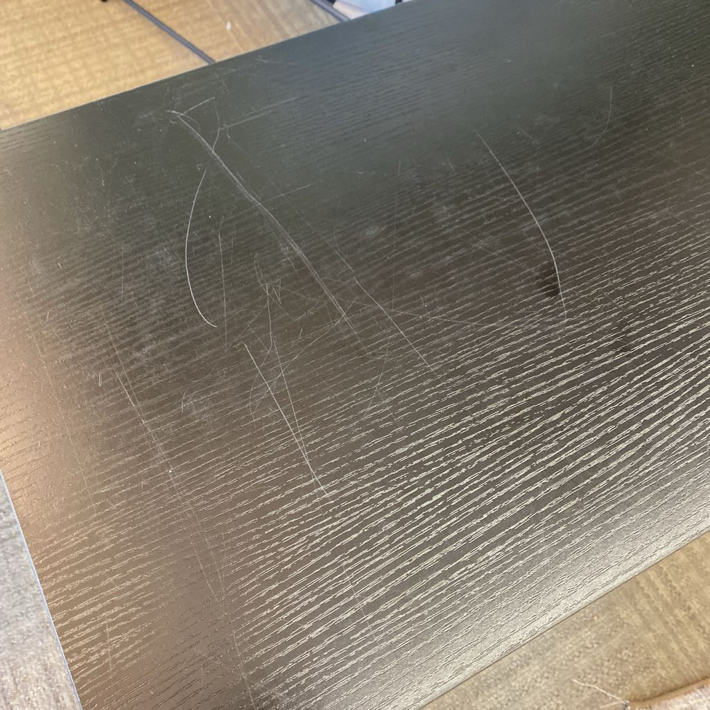 Scratched black surface on a wooden floor