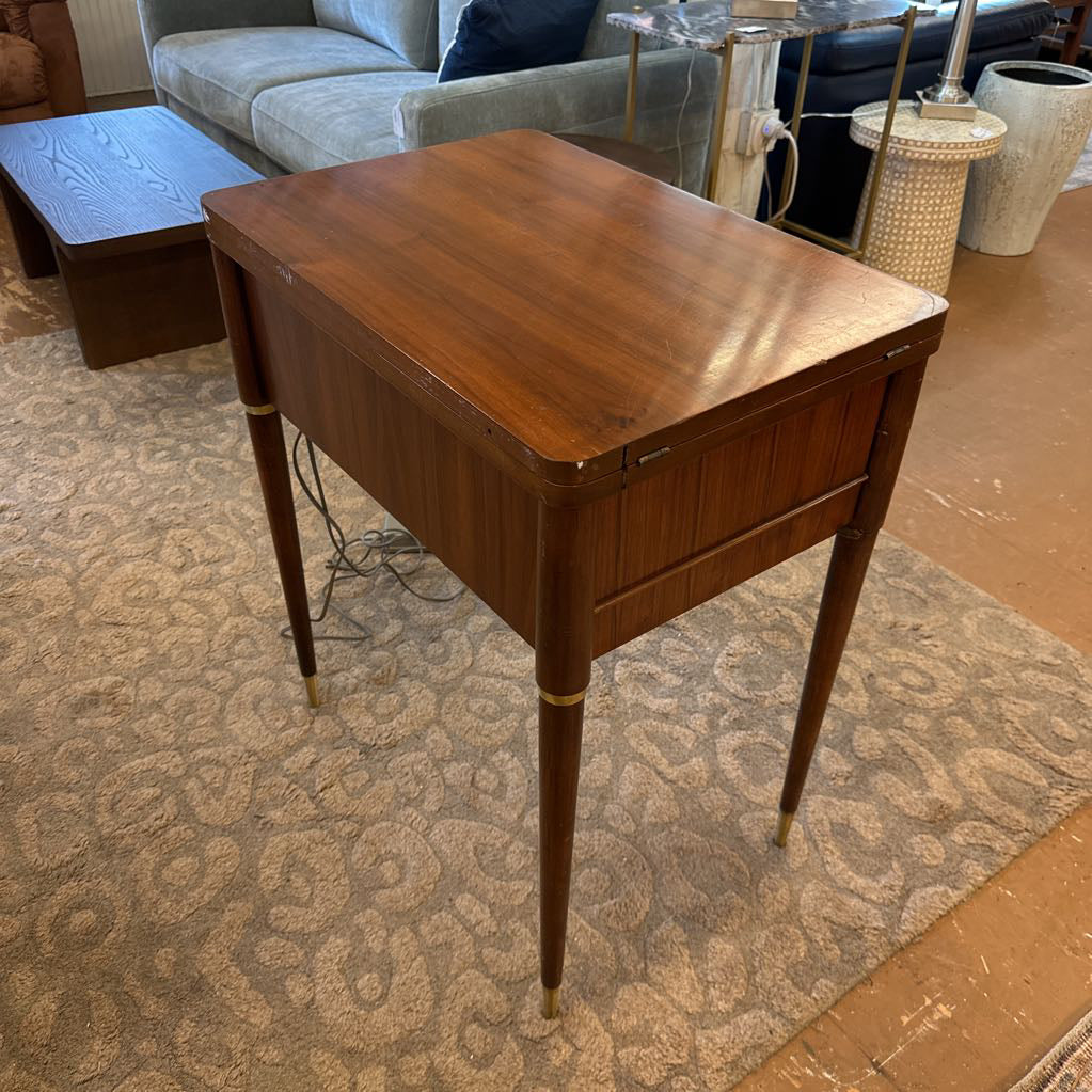 Wooden side table in a living room setting with furniture and decor items.