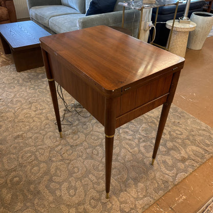 Wooden side table in a living room setting with furniture and decor items.