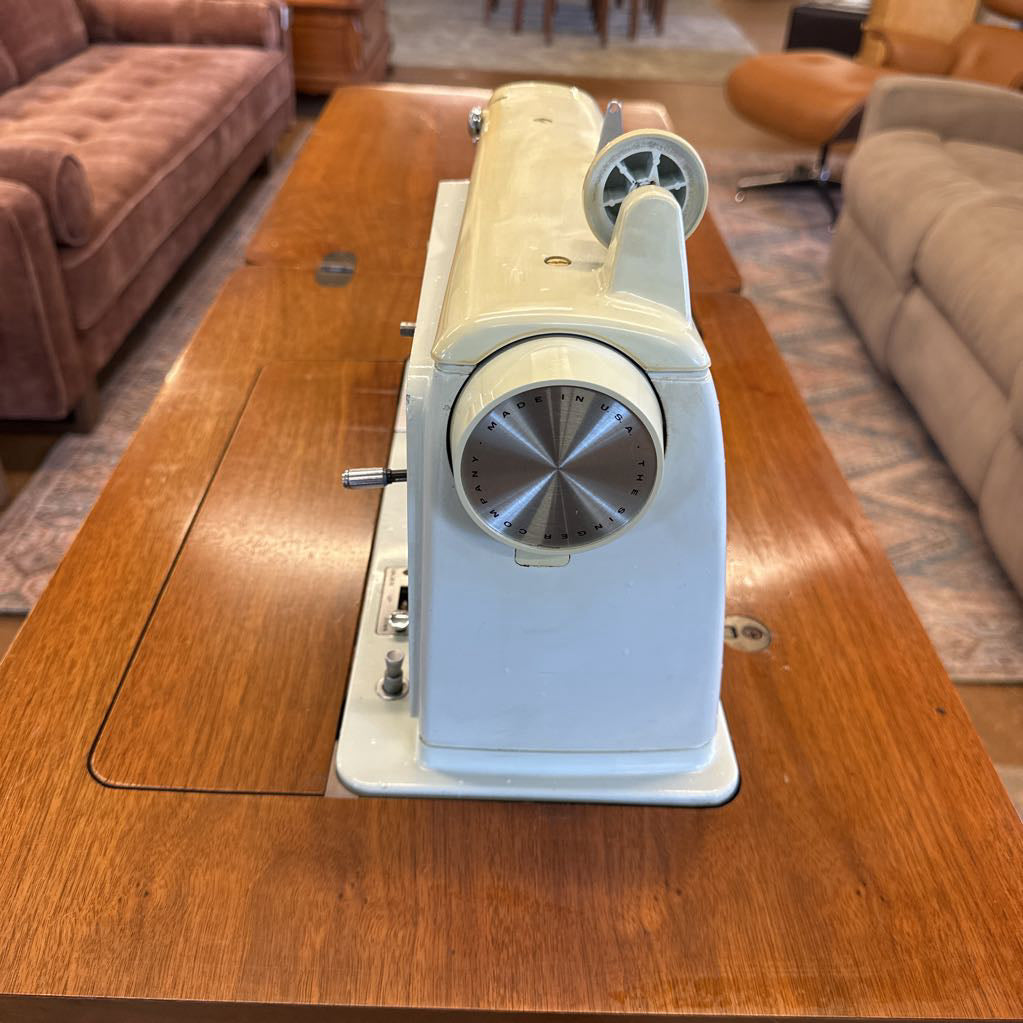 Sewing machine on a wooden table in a living room setting