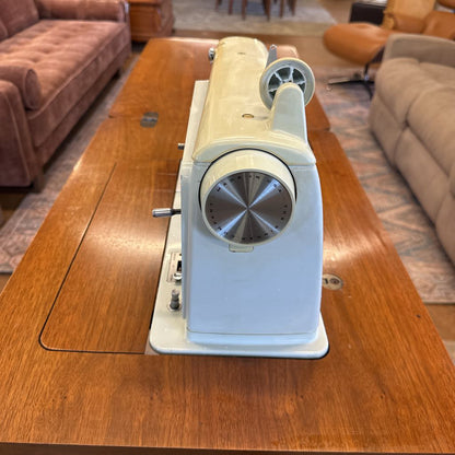 Sewing machine on a wooden table in a living room setting