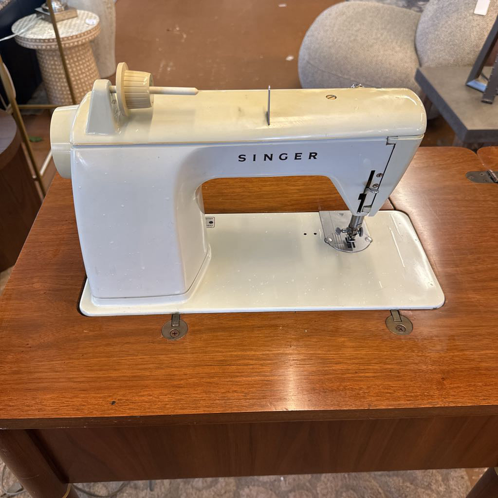 Singer sewing machine on a wooden table with a blurred background