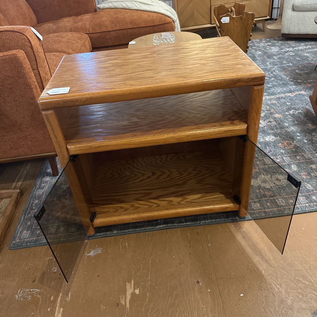 Wooden side table with glass shelf in a room setting