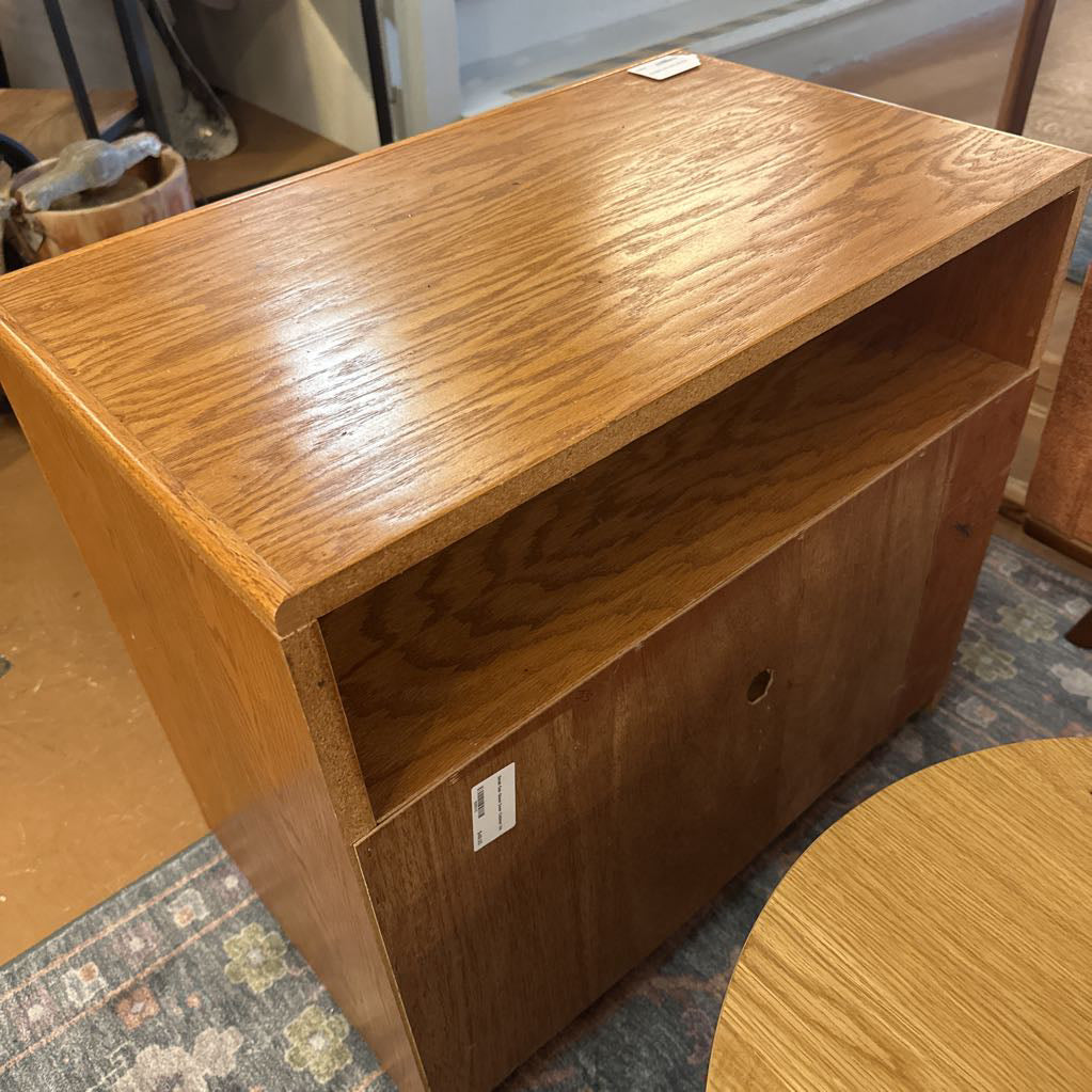 Wooden shelf with a tag on a patterned rug
