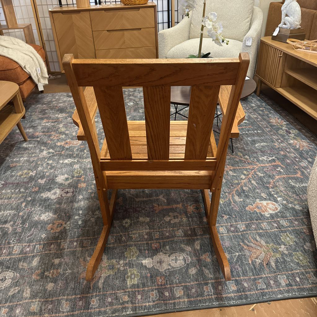 Wooden rocking chair in a room with furniture and decor.